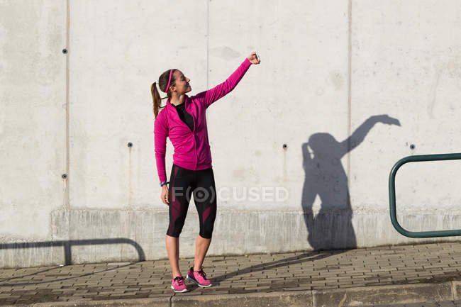 Mulher em roupas esportivas tomando selfie — Fotografia de Stock
