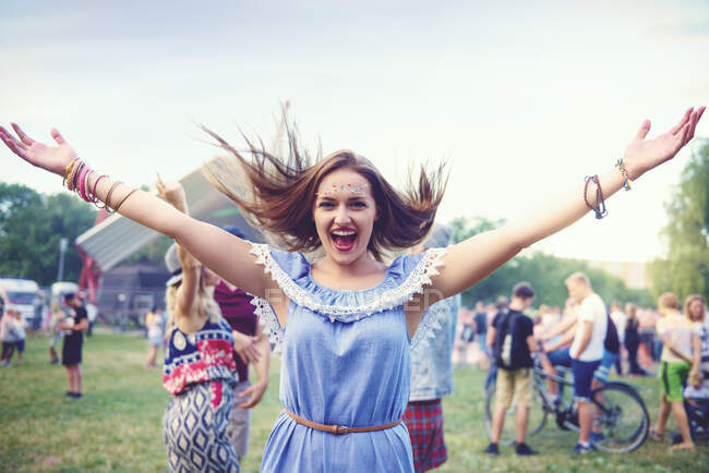 Young boho woman dancing and jumping for joy at festival — Stock Photo
