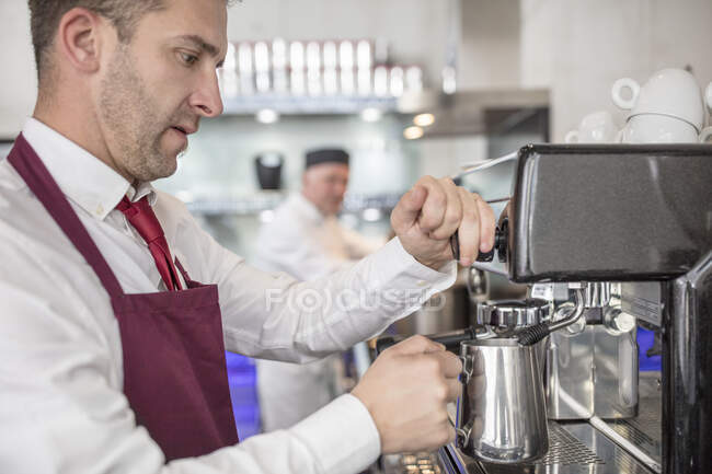 Garçom em restaurante usando máquina de café — Fotografia de Stock