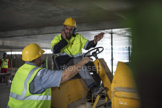 Travailleurs de la construction en discussion sur le chantier — Photo de stock