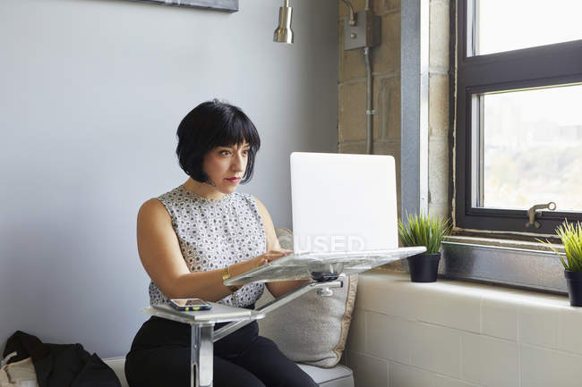 Businesswoman using laptop on laptop stand — Stock Photo