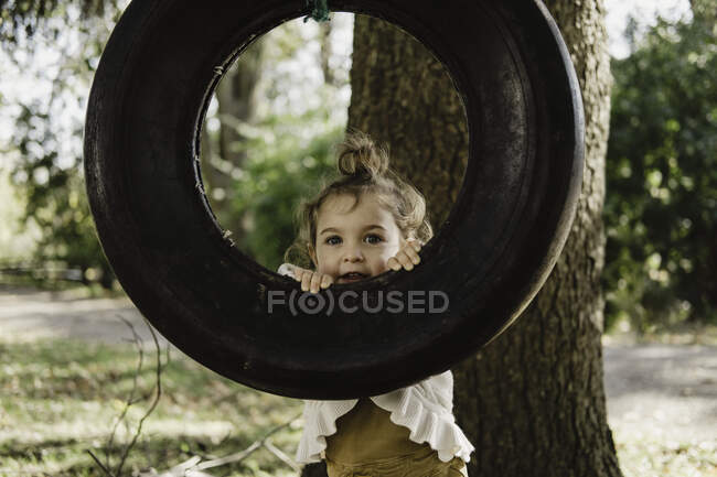 Chica en el columpio de neumáticos - foto de stock