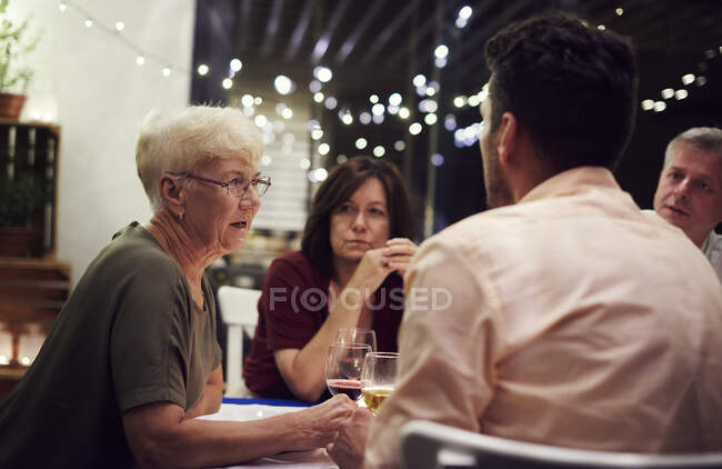 Group of people sitting at table, enjoying meal — Stock Photo