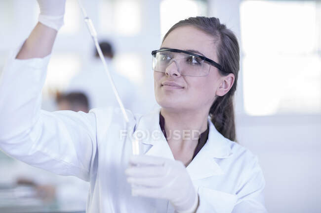 Trabajador de laboratorio haciendo experimento en laboratorio - foto de stock