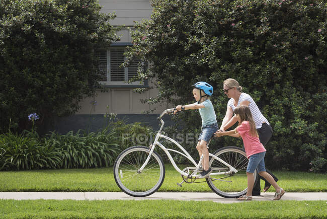 Niño en la calle aprendiendo a montar en bicicleta - foto de stock