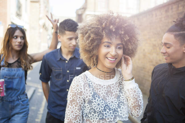 Vier junge Freunde gehen lächelnd nach draußen — Stockfoto