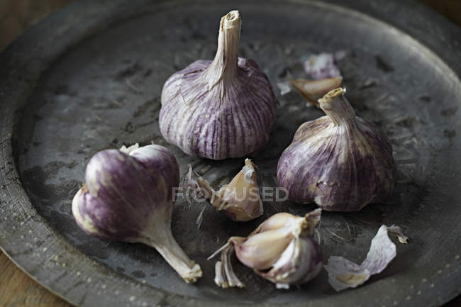 Close-up view of healthy organic garlic bulbs on tray — Stock Photo