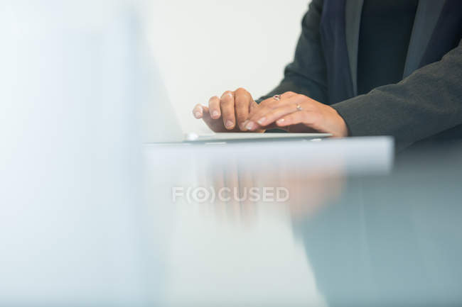 Hands of businesswoman typing on laptop at office desk — Stock Photo