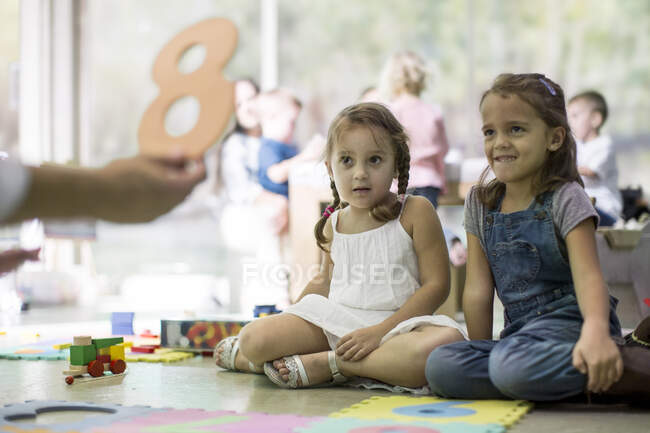 Insegnante mostrando numero ritaglio ai bambini — Foto stock