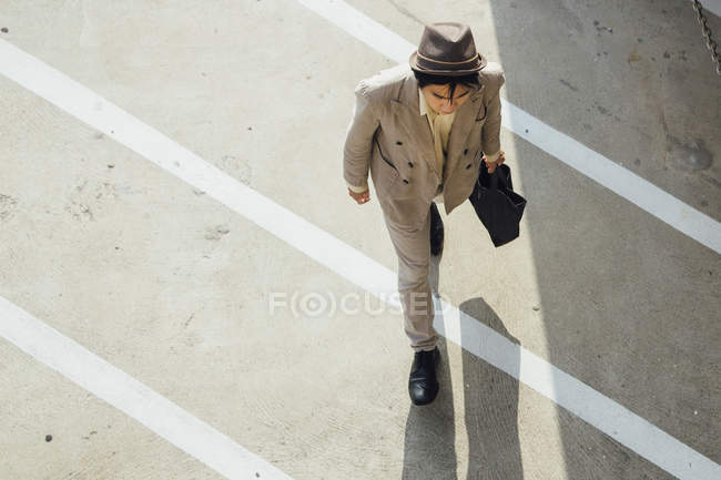 Young man walking across road — Stock Photo