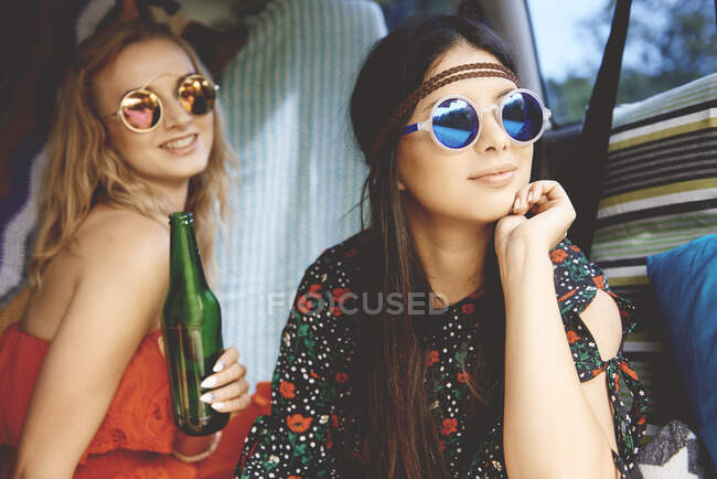 Dos jóvenes boho con gafas de sol en furgoneta recreativa - foto de stock