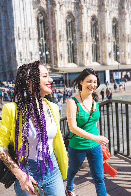 Mujeres jóvenes caminando fuera de Il Duomo, Milán, Italia - foto de stock