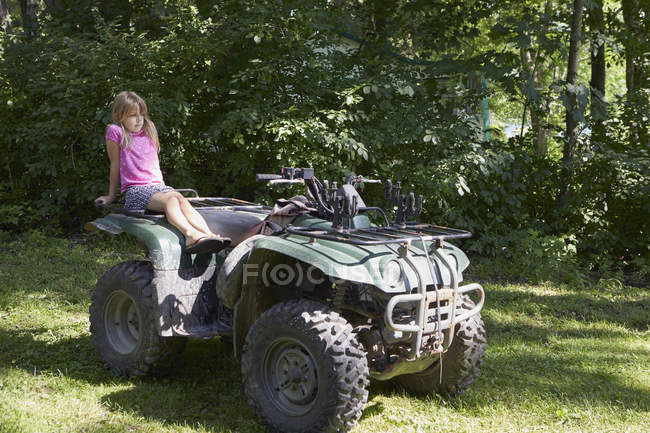 Jeune fille assise sur un quad — Photo de stock