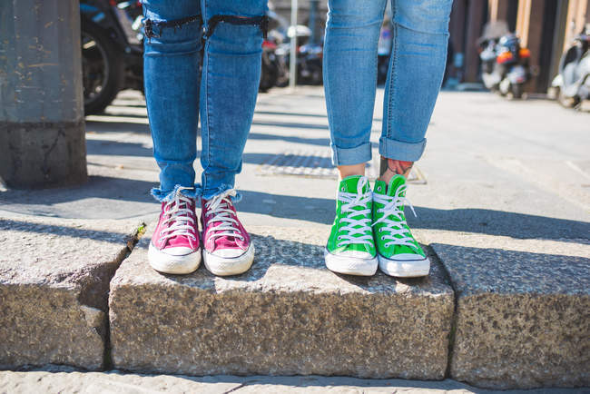Women feet in trainers on steps, Milán, Italia - foto de stock