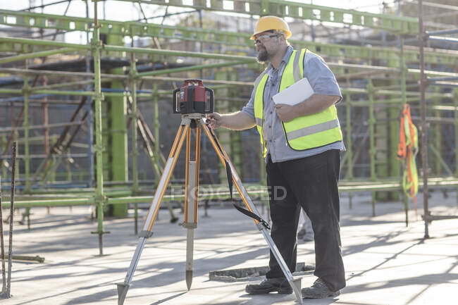 Construction worker using surveying equipment — Stock Photo