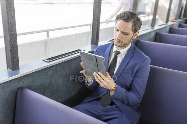 Jungunternehmer auf Passagierfähre schaut auf digitales Tablet — Stockfoto