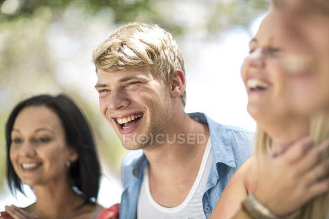 Quatro jovens e médios amigos adultos rindo na festa na praia — Fotografia de Stock