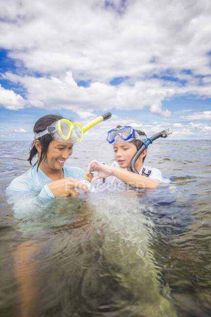 Mother and son hunting scallops together — Stock Photo