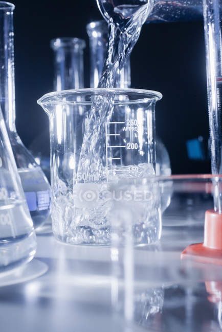 Pouring water into beaker — Stock Photo