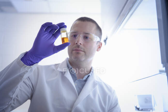 Científico inspeccionando muestra química en laboratorio — Stock Photo