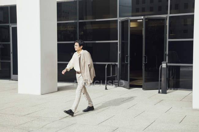 Молодой человек выходит из офисного здания — стоковое фото