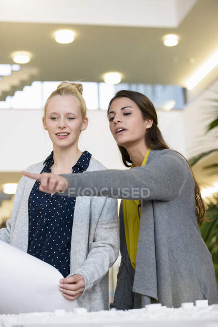 Colleagues discussing town planning drawings in office — Stock Photo