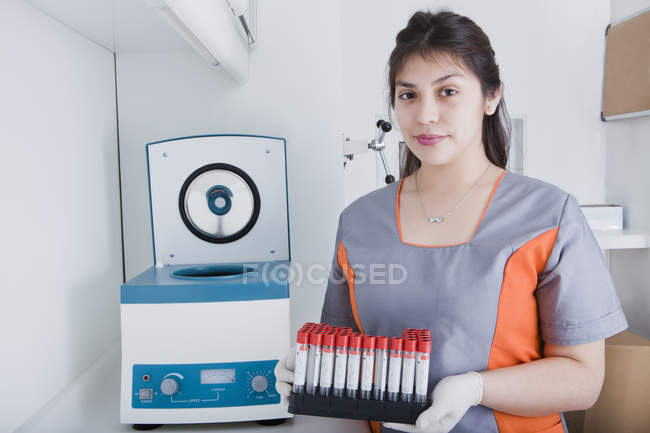 Mujer que trabaja con tubos de ensayo en laboratorio dental - foto de stock