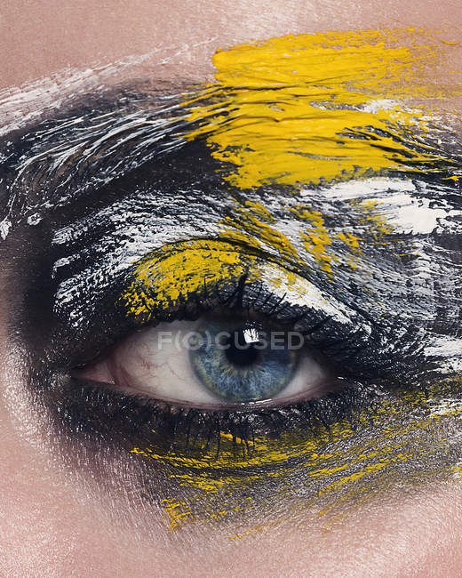 Close up of blue eyed woman with painted face — Stock Photo