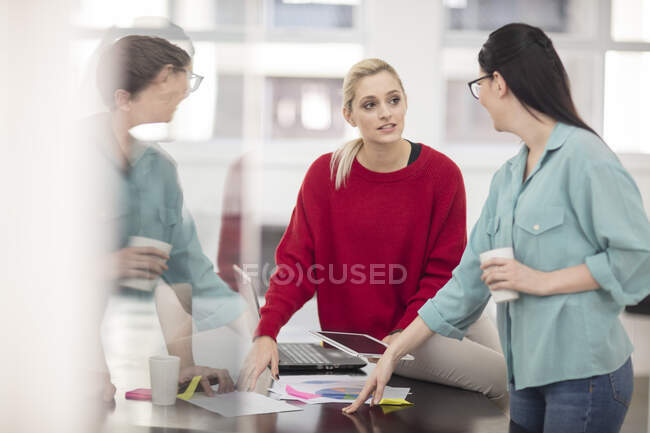 Two young female office workers meeting at office desk — Stock Photo