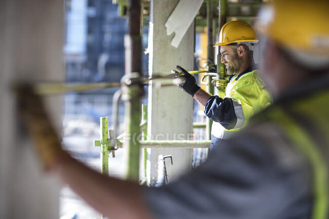 Travailleurs de la construction mesurant bâtiment — Photo de stock