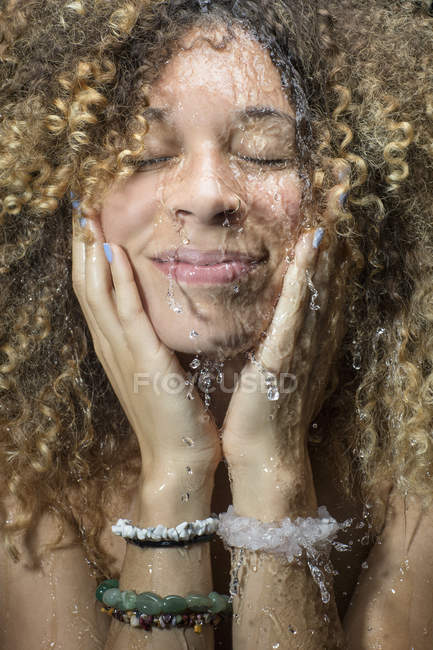 Mujer salpicando agua en la cara - foto de stock