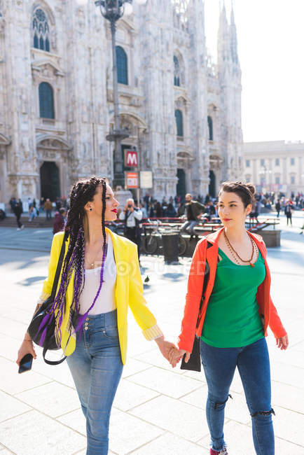 Women walking with holding hands outside Il Duomo, Milan, Italy — Stock Photo