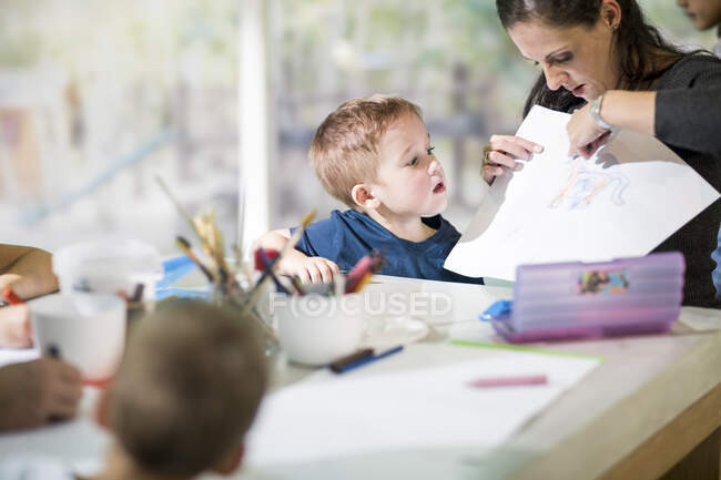 Profesor enseñando niño a dibujar - foto de stock