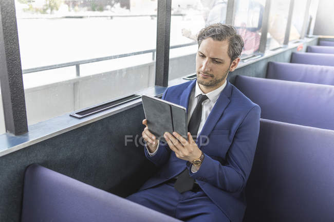 Jungunternehmer schaut auf Passagierfähre auf digitales Tablet — Stockfoto