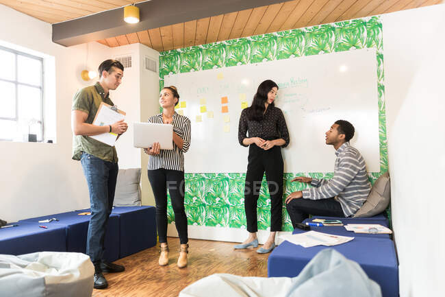 Group of businessmen and women having discussions in creative meeting room — Stock Photo