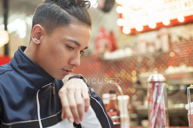 Retrato de Jovem falando em smartwatch sentado no restaurante — Fotografia de Stock