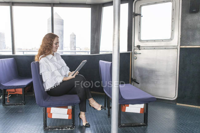 Jovem empresária elegante olhando para tablet digital em balsa de passageiros — Fotografia de Stock
