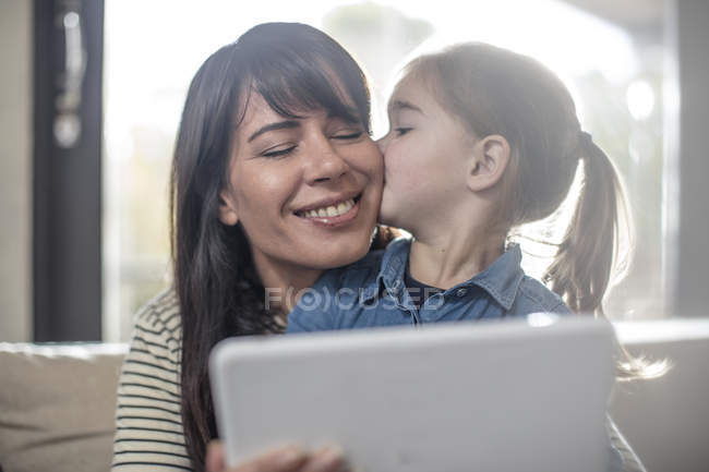 Жінки і дочка на дивані, використовуючи цифровий планшетний — стокове фото