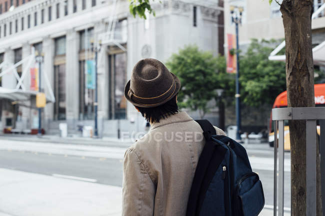 Junger Mann geht mit Rucksack ins Freie — Stockfoto
