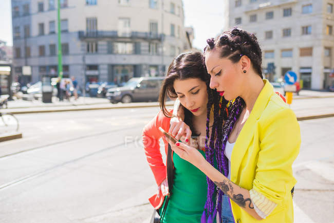 Женщины на городской улице с помощью мобильного телефона, Милан, Италия — стоковое фото