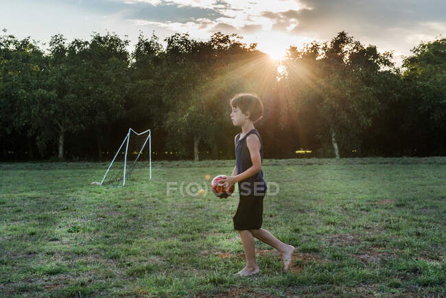 Chico jugando fútbol en parque - foto de stock