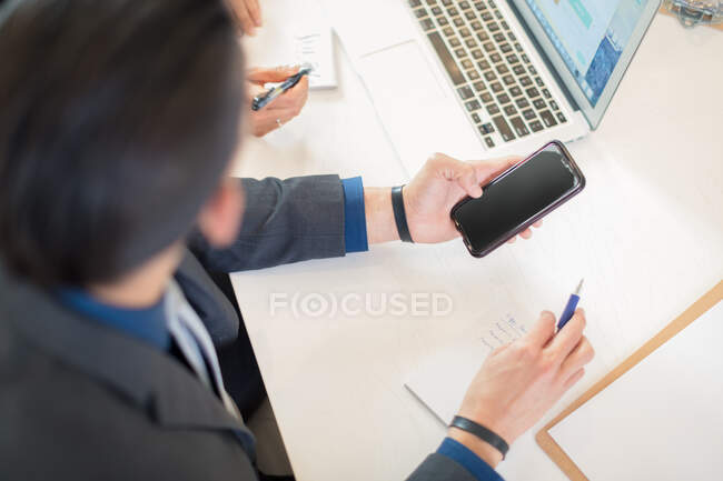 Businessman looking at smartphone at desk — Stock Photo