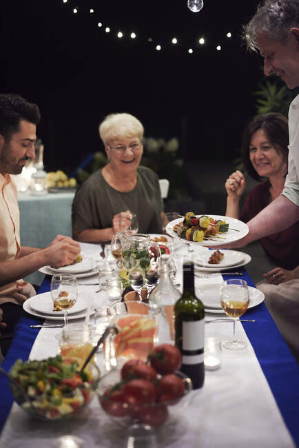 Gruppe von Menschen sitzt am Tisch und genießt das Essen — Stockfoto