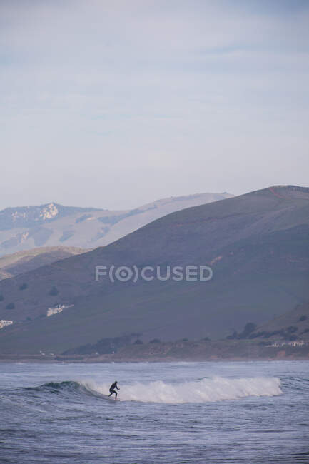 Joven surfista surfista surfing ocean wave, Morro Bay, California, EE.UU. - foto de stock
