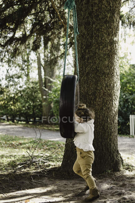 Fille sur pneus swing — Photo de stock