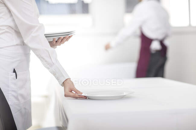 Garçonete que coloca mesa no restaurante, seção meados — Fotografia de Stock
