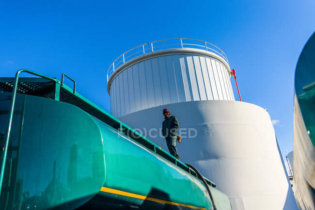 Visão de baixo ângulo do trabalhador em cima do petroleiro de biocombustível na fábrica de biocombustíveis — Fotografia de Stock