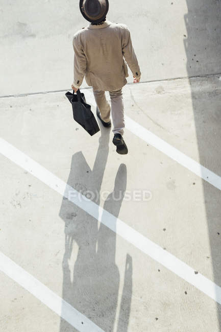 Young man walking across road — Stock Photo