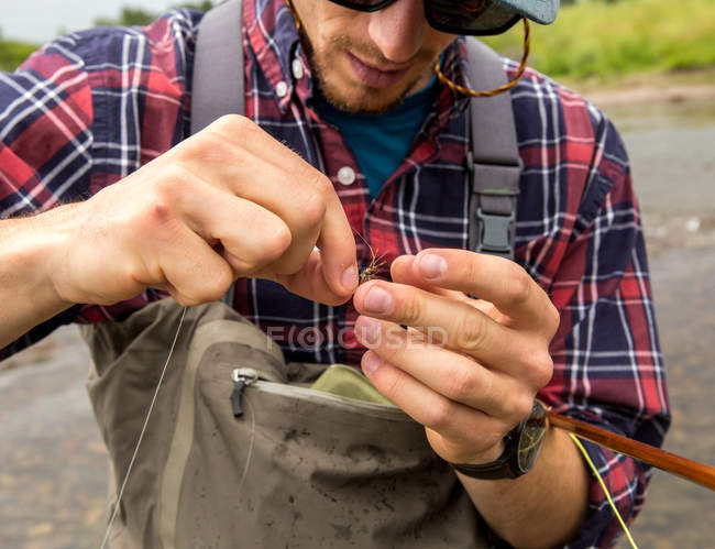 Close up of man preparing bait in river — Stock Photo