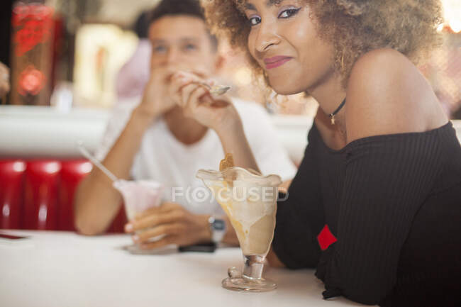Coppia giovane seduta in tavola calda, mangiare dessert, sorridere — Foto stock